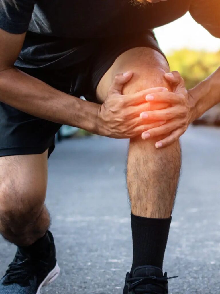 Athlete holding an unstable knee during sports activity after a ligament injury.